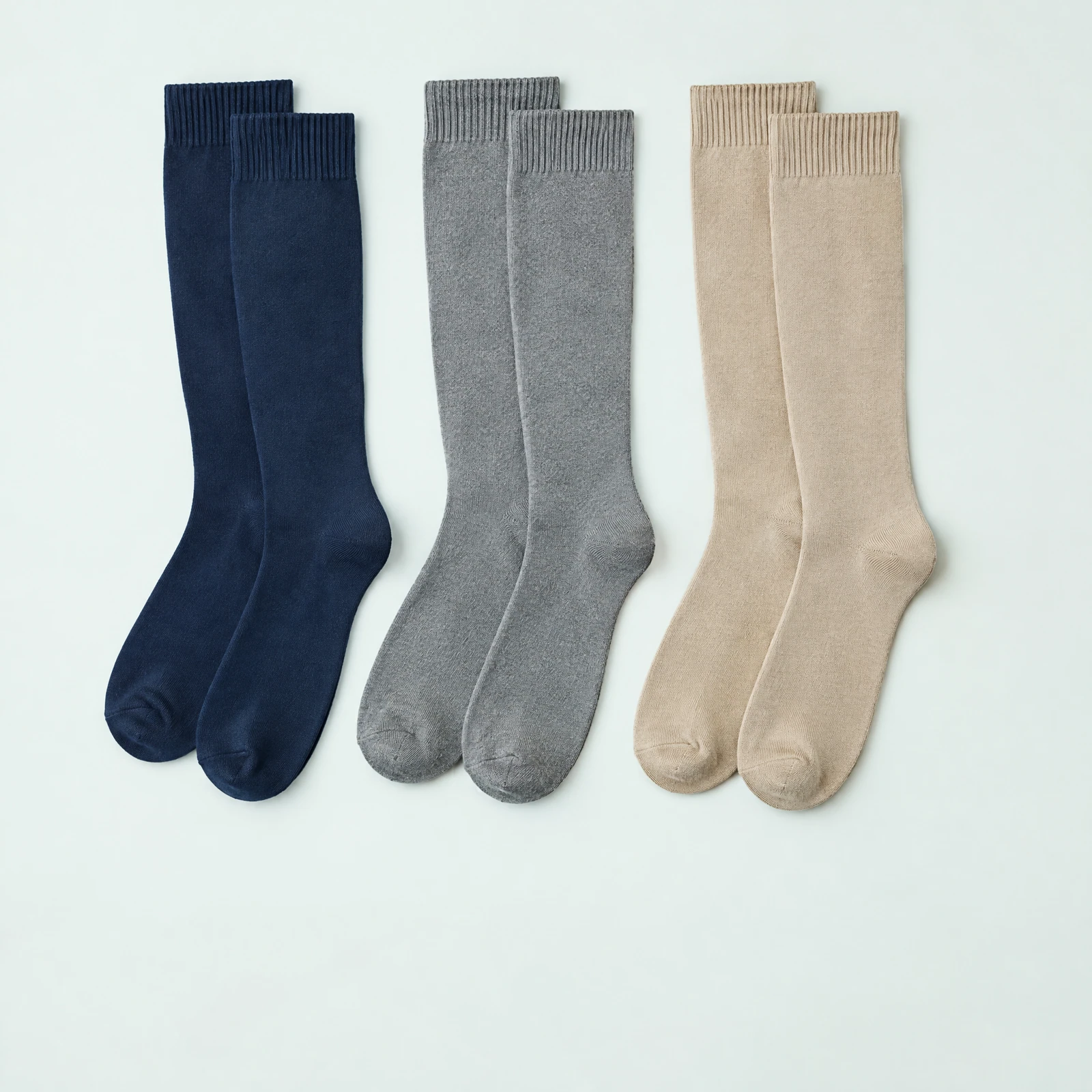 Three pairs of knee-high socks in navy, gray and beige arranged side by side